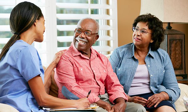 Senior couple talking with nurse